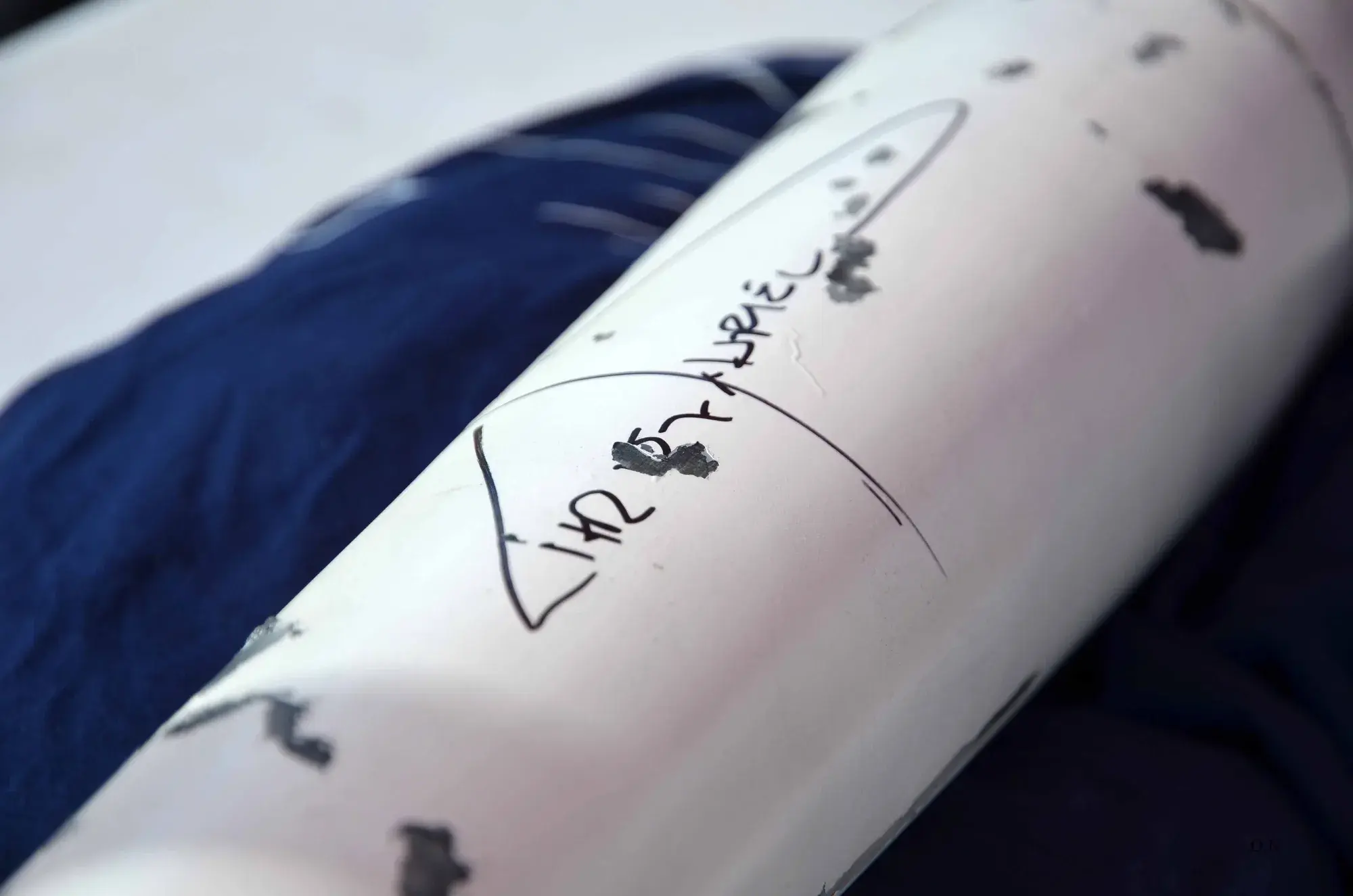Close-up of Chris Hadfield's signature on the recovered nosecone, white paint chipped away from drag on the way down.