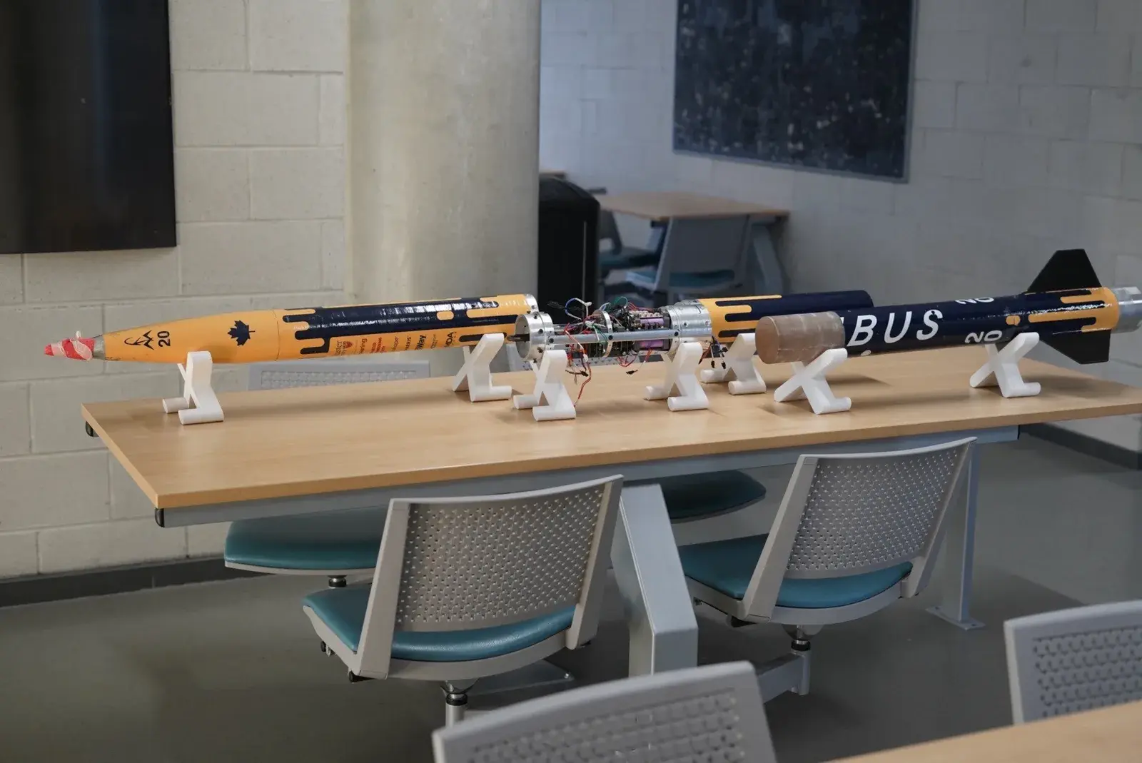Nimbus laid out in two sections on a table with the avionics bay open between them, during an on-campus info session.