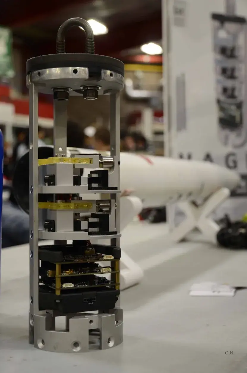 The Magpie team with the payload on display at Launch Canada, competition poster behind.