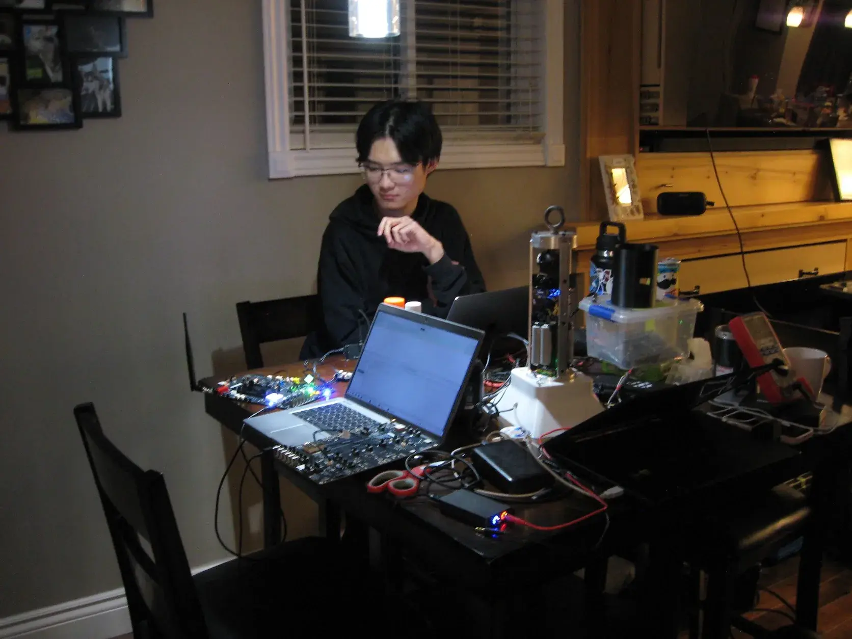 A team member at the bench with Sparrow, a laptop, and SRAD boards wired for testing.