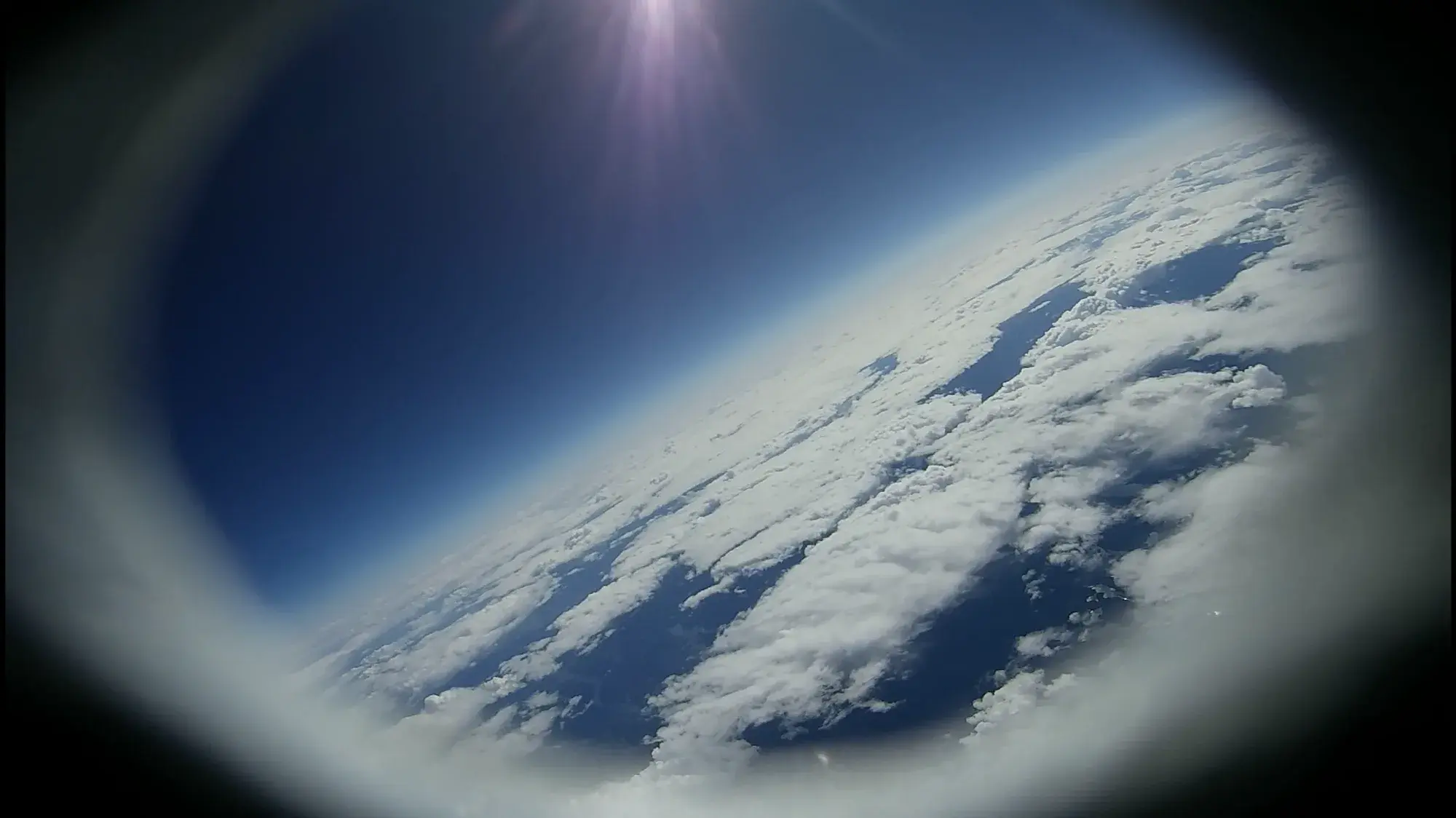 360-degree camera view from Sparrow in flight: cloud deck and blue sky through the circular lens.