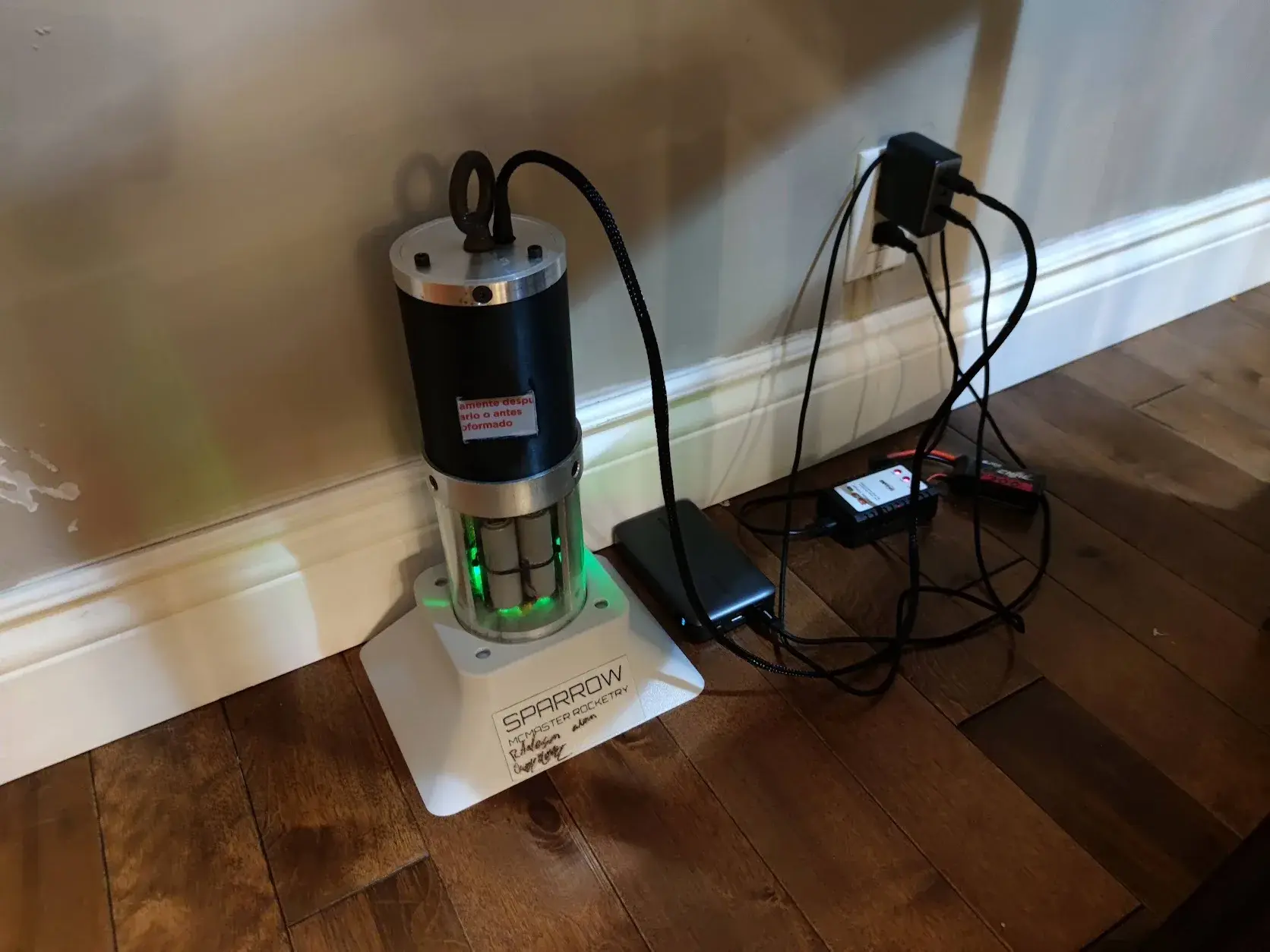 Sparrow standing on its base, plugged in and charging.