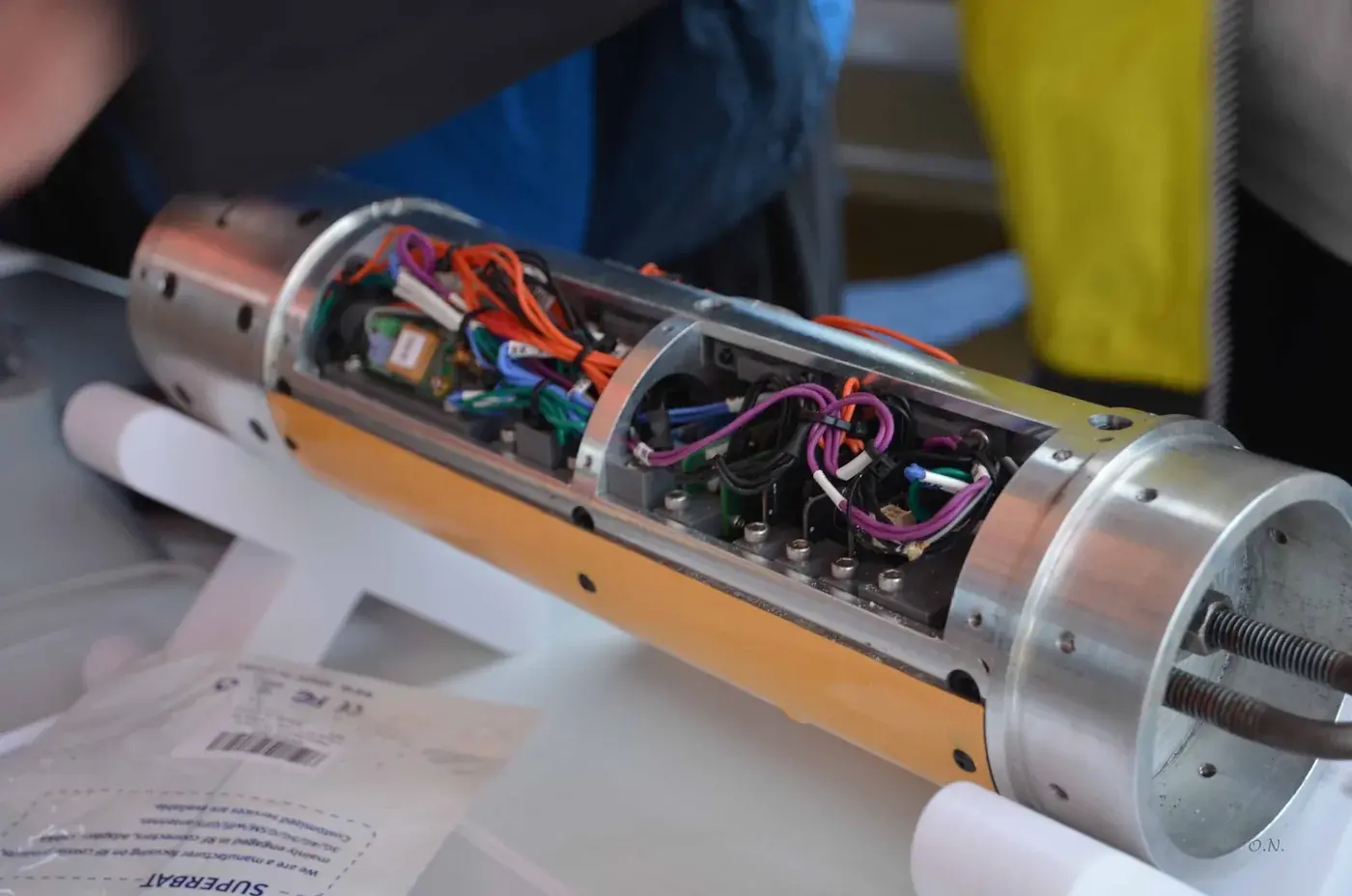 The open avionics bay on the yellow Nimbus airframe, wiring and flight hardware visible.